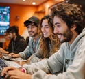 Fotografía publicitaria para portada de video de miniatura youtube 16:9 muy ancha ;super hiperrealista de un grupo de latinos , con expresiónes amables, . Están estudiando con su portatil cada uno, miran a su profesor con actitud cercana y amigable , que les enseña en una pantalla gigante señales de trading. Visten ropa casual moderna. Sus estilos transmite frescura, confianza y felicidad. El fondo muestra una oficina moderna. con un tono naranja desenfocado --v 7 Job ID: bc0c4126-6725-4d8c-a1cb-2952e309d5ca